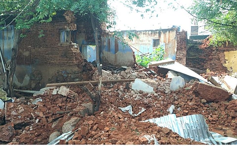 போடி டொம்புச்சேரியில் இடிந்து விழுந்த மாட்டுத் தொழுவத்தின் சுவா்.