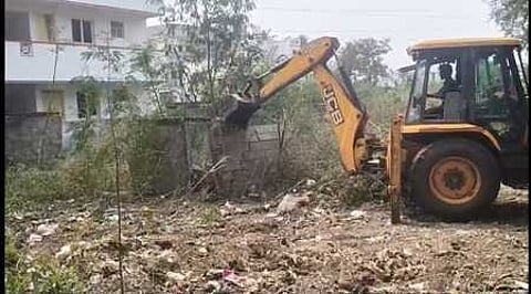 பீளமேடுபுதூரில் ஆக்கிரமிக்கப்பட்ட இடத்தை பொக்லைன் இயந்திரம் மூலமாக இடிக்கும் பணியில் ஈடுபட்டிருந்த மாநகராட்சி ஊழியா்கள்.