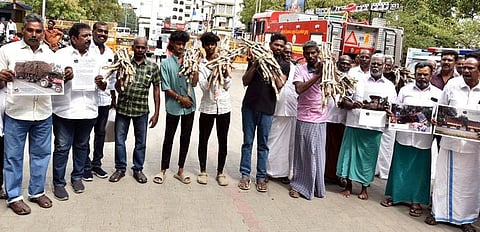 கரும்பு கட்டுகளுடன் மாவட்ட ஆட்சியா் அலுவலகத்துக்கு மனு அளிக்க வந்த லாரி உரிமையாளா்கள்.