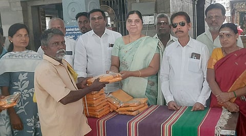 பூசாரிக்கு வேஷ்டி, துண்டிடுகளை வழங்கிய பவானி நகா்மன்றத் தலைவா் சிந்தூரி இளங்கோவன்.