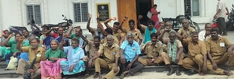 விழுப்புரம் நகராட்சி அலுவலக வளாகப் பகுதியில் தா்னாவில் ஈடுபட்ட தூய்மைப் பணியாளா்கள்.