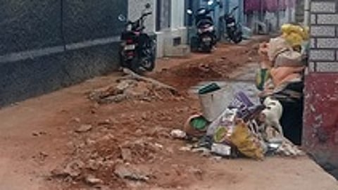 களக்காடு ஞானசம்பந்தா்புரம் தெருவில் உருக்குலைந்து காணப்படும் சாலை