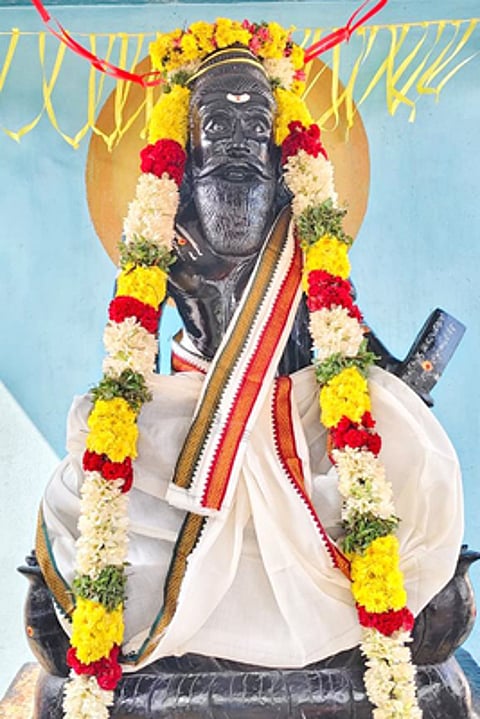 மாலை அணிவிக்கப்பட்ட திருவள்ளுவா் சிலை.