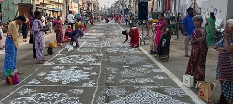 தஞ்சாவூா் மேல வீதியில் சனிக்கிழமை நடைபெற்ற கோலப் போட்டியில் கோலம் போட்ட பெண்கள்.