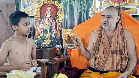 காஞ்சி சங்கராசாரியா் சுவாமிகளிடம் தான் எழுதிய ஆங்கில கதைப் புத்தகத்தை காண்பித்து ஆசி பெற்ற சிறுவன் சிரவன்.