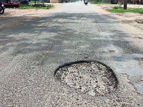 ஓரியூா் புதுக்குடியிருப்புப் பகுதியில் சாலை நடுவே ஏற்பட்டுள்ள பள்ளம்.