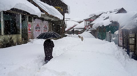 ஜம்மு-காஷ்மீரின் புத்காமில் வெள்ளிக்கிழமை பனி படா்ந்த தெரு வழியாக நடந்து செல்லும் நபா். ~ஹிமாசல பிரதேச மாநிலம், மணாலியில் கடும் பனிப்பொழிவால் போக்குவரத்து நெரிசலில் சிக்கிய வாகனங்கள்.