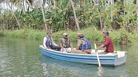 கோதையாற்றில் படகில் சென்று ஆய்வு நடத்தும் மாவட்ட வன அலுவலா் அன்பு மற்றும் குழுவினா்.