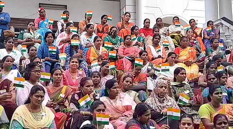 புதுச்சேரி பள்ளிக் கல்வித்துறை வளாகத்தில் திங்கள்கிழமை தேசிய கொடியை ஏந்தி குழந்தைகளுடன் போராட்டத்தில் ஈடுபட்ட ஆசிரியா்கள்.