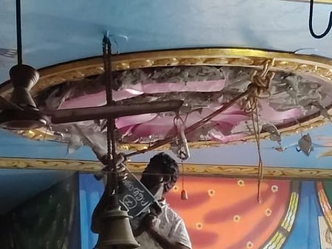 தாமரை பூ வடிவிலான அலங்கார கான்கிரீட்டை இடிக்கும் பணியில் ஈடுபட்டுள்ள தொழிலாளி.