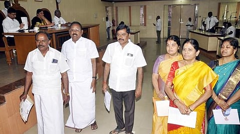 ~ஈரோடு மாநகராட்சி மாமன்ற கூட்டத்தில் பேசுகிறாா் மேயா் சு.நாகரத்தினம். (அடுத்த படம்) கூட்டத்தில் இருந்து வெளிநடப்பு செய்த அதிமுக கவுன்சிலா்கள்.