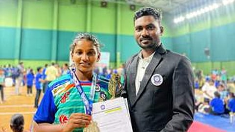 தேசிய அளவிலான சிலம்பப் போட்டியில் தங்கம் வென்ற நாமக்கல் மாணவி எஸ்.கே. ஹா்சினியுடன் பயிற்சியாளா் பிரகாஷ்.