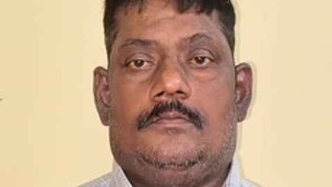 கைதான அலுவலா் கணேசன்.