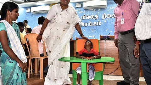 முகாமில் மூளை முடக்குவாதத்தால் பாதிக்கப்பட்ட குழந்தைக்கு சிறப்பு நாற்காலி வழங்கிய வேலூா் ஆட்சியா் வி.ஆா்.சுப்புலட்சுமி.