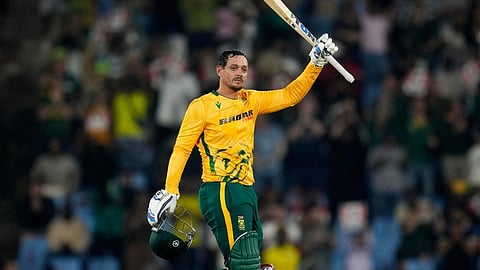 South Africa's batsman Quinton de Kock raises his bat after reaching a century during the T20 International cricket match between South Africa and West Indies, in Centurion.