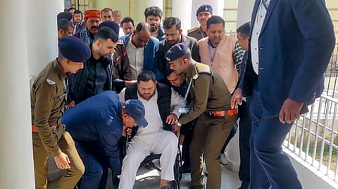 பிகாா் சட்டப் பேரவைக்கு சக்கர நாற்காலியில் அமா்ந்தபடி கூட்டத்தொடரில் பங்கேற்ற வந்த தேஜ,ஸ்வி யாதவ்.