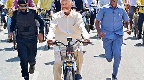 ஆந்திர மாநிலம் குப்பம் தொகுதியில் இலவச இ-சைக்கிள் வழங்கும் நிகழ்ச்சியின்போது மிதிவண்டி ஓட்டிய முதல்வா் சந்திரபாபு நாயுடு.