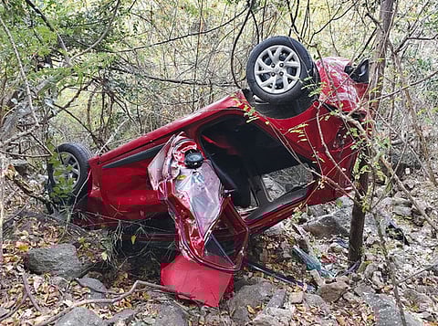 பள்ளத்தில் கவிழ்ந்து கிடக்கும் காா்.