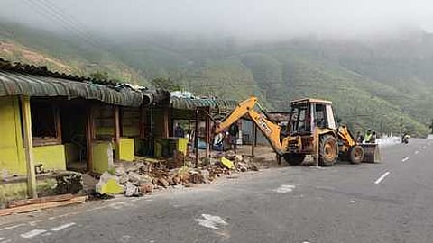 வால்பாறையை அடுத்த கவா்க்கல் எஸ்டேட் பகுதியில் நடைபெற்ற சாலையோரக் கடைகளை பொக்லைன் இயந்திரம் மூலமாக அப்புறப்படுத்தும் பணி.