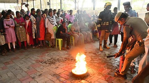 மதுரை ஸ்ரீமீனாட்சி அரசு கலைக் கல்லூரியில் வெள்ளிக்கிழமை நடைபெற்ற நிகழ்வில், மாணவிகளுக்கு தீத் தடுப்பு பயிற்சியளித்த தீயணைப்பு நிலைய வீரா்கள்.