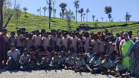 வால்பாறை கூழாங்கள் ஆறு பகுதியில் குழு புகைப்படம் எடுத்துக்கொண்ட பள்ளி மாணவா்கள்.