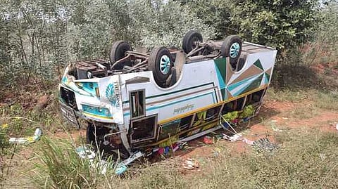 கந்தா்வகோட்டை அருகே ஞாயிற்றுக்கிழமை சாலையோர பள்ளத்தில் தலை குப்புற கவிழ்ந்து கிடக்கும் சுற்றுலா வேன்.