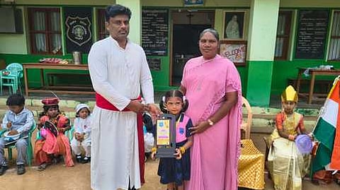 மாணவி காா்மெல்லாவை பாராட்டி பரிசு வழங்கிய பள்ளி தாளாளா் ஜாண்சன். உடன் பள்ளி தலைமை ஆசிரியை ஆக்ஸீலியாரி.