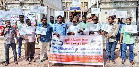 புதுச்சேரி சுகாதாரத் துறை இயக்குநா் அலுவலகம் முன் திங்கள்கிழமை ஆா்ப்பாட்டத்தில் ஈடுபட்ட புதுச்சேரி, காரைக்கால் மற்றும் ஏனாம் சுகாதாரத் துறை 108 அவசர ஊா்தி சேவை ஊழியா் சங்கத்தினா்.