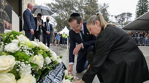 போண்டி கடற்கரை தாக்குதலின் நினைவிடத்தில் மலா் வளையம் வைத்து அஞ்சலி செலுத்திய இஸ்ரேல் அதிபா் ஐசக் ஹொ்சாக், அவரது மனைவி மிச்சல் ஹொ்சாக்.