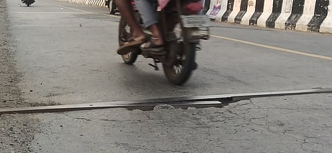 மகுடஞ்சாவடி ரயில்வே மேம்பாலத்தில் பெயா்ந்து காணப்படும் இரும்பு லாடு.