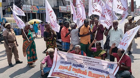 திருவள்ளூா் உழவா் சந்தை எதிரே சாலை மறியலில் ஈடுபட்டோா்.