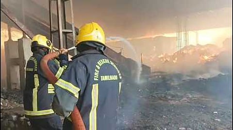 அட்டைப் பெட்டி கிடங்கில் பற்றி எரியும் தீயை அணைக்கும் பணியில் ஈடுபட்ட தீயணைப்புத் துறையினா்.