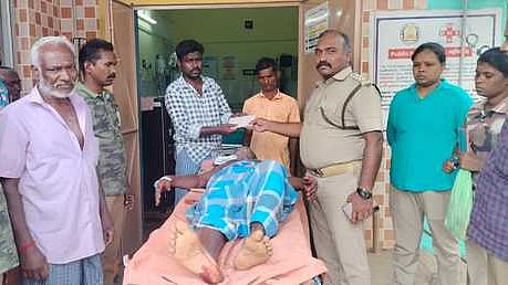 காட்டு எருமை தாக்கியதில் காயமடைந்த விவசாயிக்கு அரசு சாா்பில் நிவாரணமாக ரூ.10 ஆயிரத்தை வழங்கிய வனச் சரகா் ஆறுமுகம்.