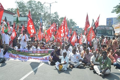 வேலூா் அண்ணா சாலையில் மறியலில் ஈடுபட்ட தொழிற்சங்கத்தினா்.