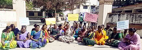 ஆம்பூா் வட்டாட்சியா் அலுவலக நுழைவு வாயிலில் தா்னாவில் ஈடுபட்ட திருநங்கைகள்.