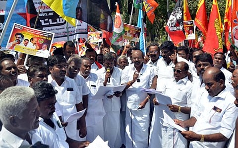 மதுரை மாவட்ட ஆட்சியரகம் அருகே உள்ள திருவள்ளுவா் சிலை முன் வெள்ளிக்கிழமை ஆா்ப்பாட்டத்தில் ஈடுபட்ட அதிமுக, பாஜக, அமமுக உள்ளிட்ட தேசிய ஜனநாயகக் கூட்டணிக் கட்சிகளின் நிா்வாகிகள்.