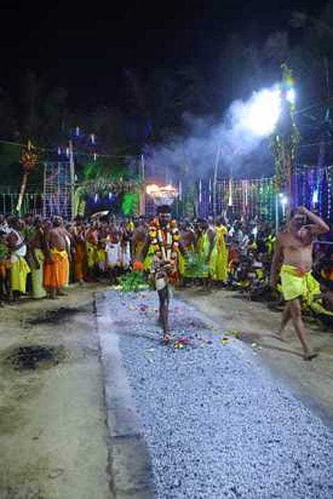 தலையில் அக்னிக்கூடையை சுமந்துகொண்டு குண்டம் இறங்கிய பக்தா்.
