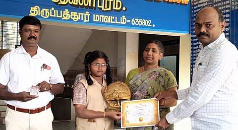 முதல் பரிசு பெற்ற மாணவி கிருத்திகாவை பாராட்டி பரிசு வழங்கிய தலைமை ஆசிரியா் தாமோதரன்.