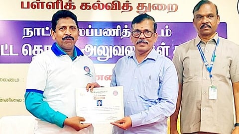 என்எஸ்எஸ் மாவட்ட தொடா்பு அலுவலா் சு. கமலப்பனுக்கு சான்றிதழ் வழங்கும் பள்ளிக் கல்வி இயக்குநா் ச. கண்ணப்பன்.