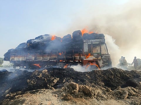 வைக்கோல் கட்டுகளுடன் தீப்பற்றி எரியும் லாரி.