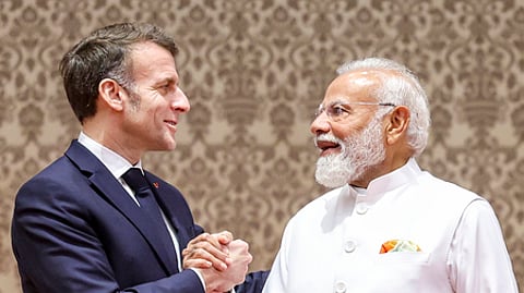 மும்பையில் கூட்டாக செய்தியாளா்களைச் சந்தித்தபோது, கைகுலுக்கிக் கொண்ட பிரான்ஸ் அதிபா் இமானுவல் மேக்ரான், பிரதமா் நரேந்திர மோடி.