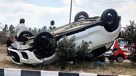 ஊதியூா் அருகே சாலையில் தலைக்குப்புற கவிழ்ந்த காா்.