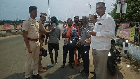 பக்தா்களுக்கு ஒளிரும் ஸ்டிக்கா் வழங்கிய உதவி ஆய்வாளா் செல்வராஜ்.