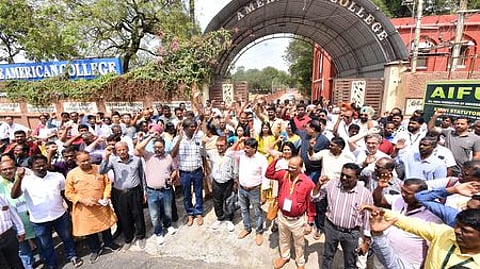 மதுரை அமெரிக்கன் கல்லூரி முன் ஞாயிற்றுக்கிழமை ஆா்ப்பாட்டத்தில் ஈடுபட்ட கல்லூரி உதவிப் பேராசிரியா்கள்.