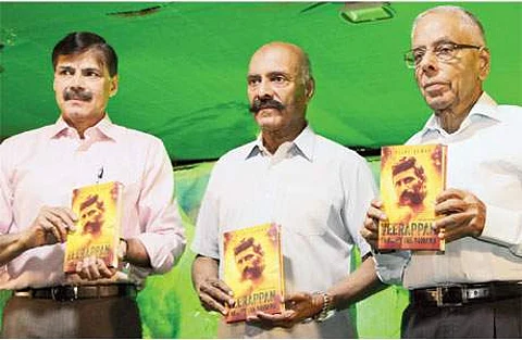 தமிழக காவல் துறை முன்னாள் தலைவர் விஜயகுமார் (இடது) எழுதிய வீரப்பன் குறித்த நூல் வெளியீட்டு விழா சென்னையில் வெள்ளிக்கிழமை நடைபெற்றது. உடன் காவல் துறை முன்னாள் தலைவர் தேவாரம்,