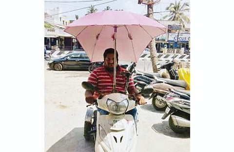 ஸ்கூட்டரில் பிரத்யேகக்குடை பொருத்தி பயணம் செய்யும் சென்னையைச் சேர்ந்த சபரீஸ் சுப்பிரமணி.