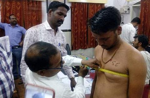 மத்தியப் பிரதேசத்தின் தார் மாவட்டத்தில் சனிக்கிழமை நடைபெற்ற காவலர் தேர்வுக்கான உடல் தகுதி பரிசோதனையின்போது மார்பில் 'எஸ்.சி.' என்று எழுதப்பட்ட நிலையில் பங்கேற்ற இளைஞர்.