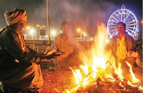 கர்நாடக மாநிலத்தில் கடும் குளிர் நிலவுவதையொட்டி, ஆங்காங்கே தீ மூட்டி குளிர் காயும் பொதுமக்கள்.