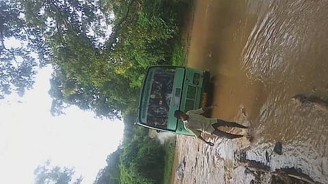 மாக்கம்பாளையம் சா்க்கரை பள்ளத்தைக் கடந்து செல்லும் அரசுப் பேருந்து.