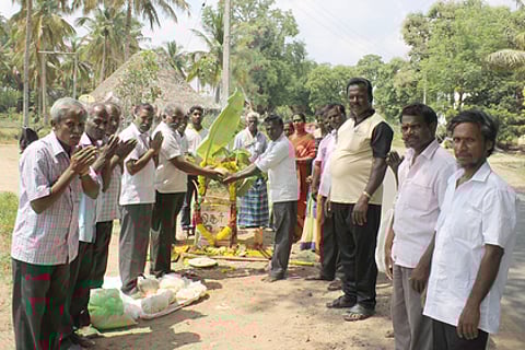 போச்சம்பள்ளி அருகே சாலையோர மைல் கல்லுக்கு பூஜை செய்து வழிபட்ட சாலைப் பணியாளா்கள்.